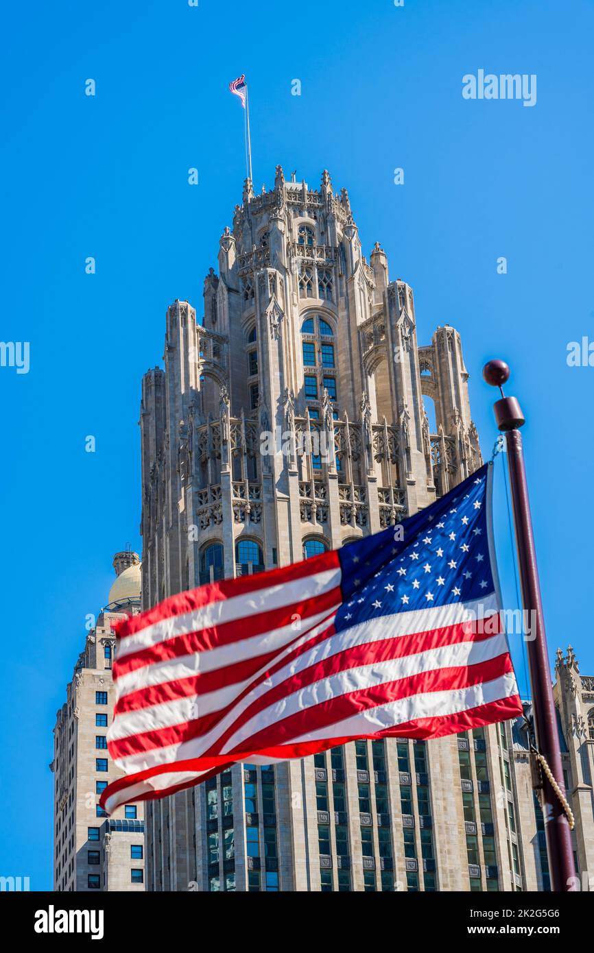 Sventolando la bandiera degli Stati Uniti con Tribune Tower dietro, Chicago, Illinois, USA Foto Stock