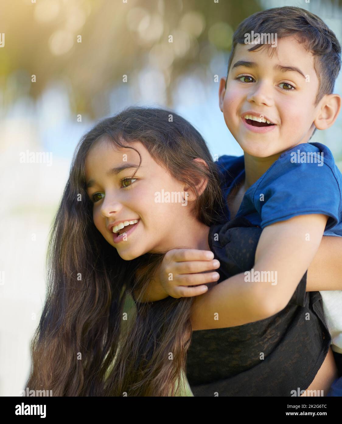 In seguito, rubato. Scatto di una ragazza piccola carina che dà a suo fratello un giro di piggyback a casa. Foto Stock