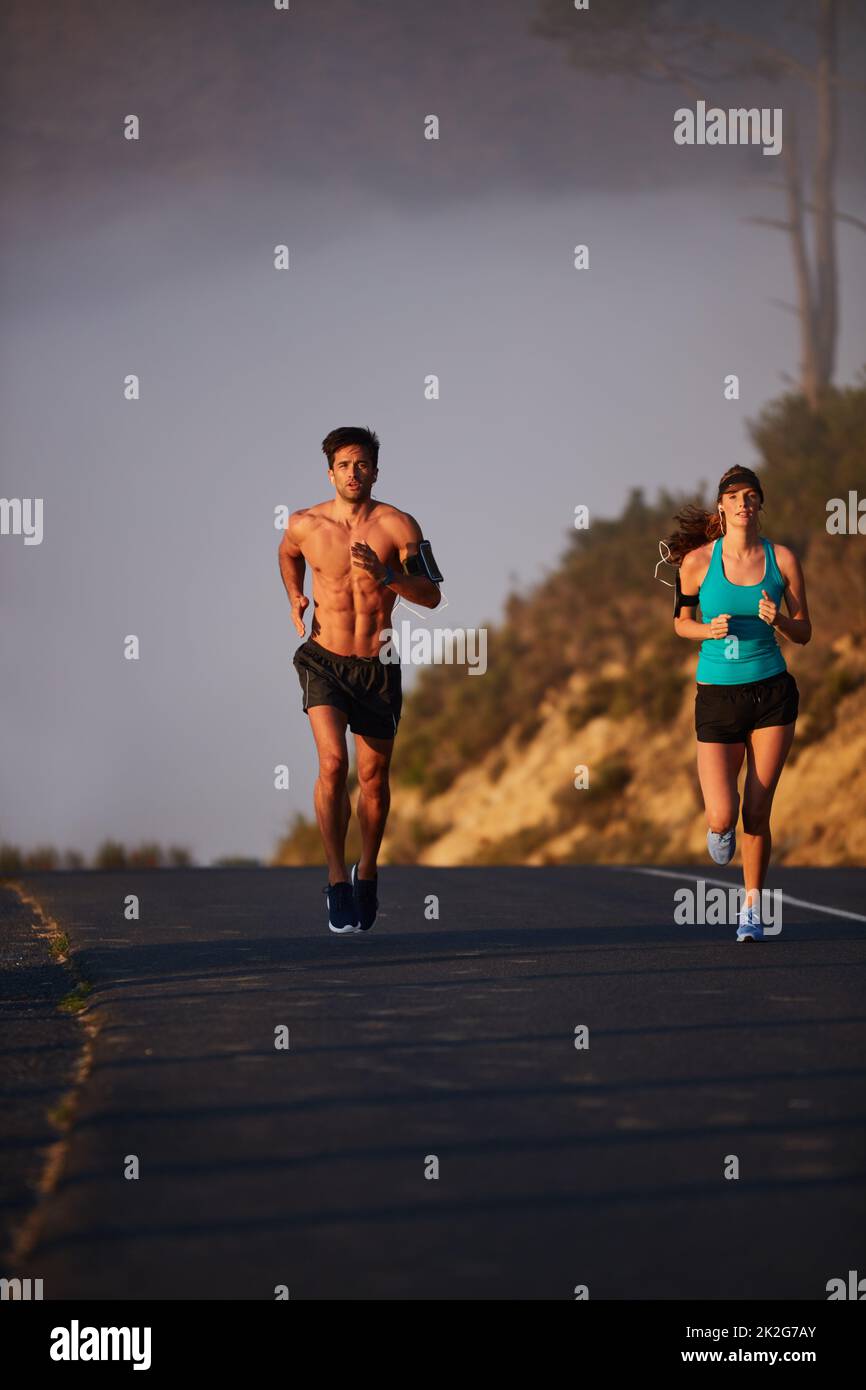 Meno preoccupazioni, più correre. Scatto di una giovane coppia atletica fuori per una corsa al mattino. Foto Stock