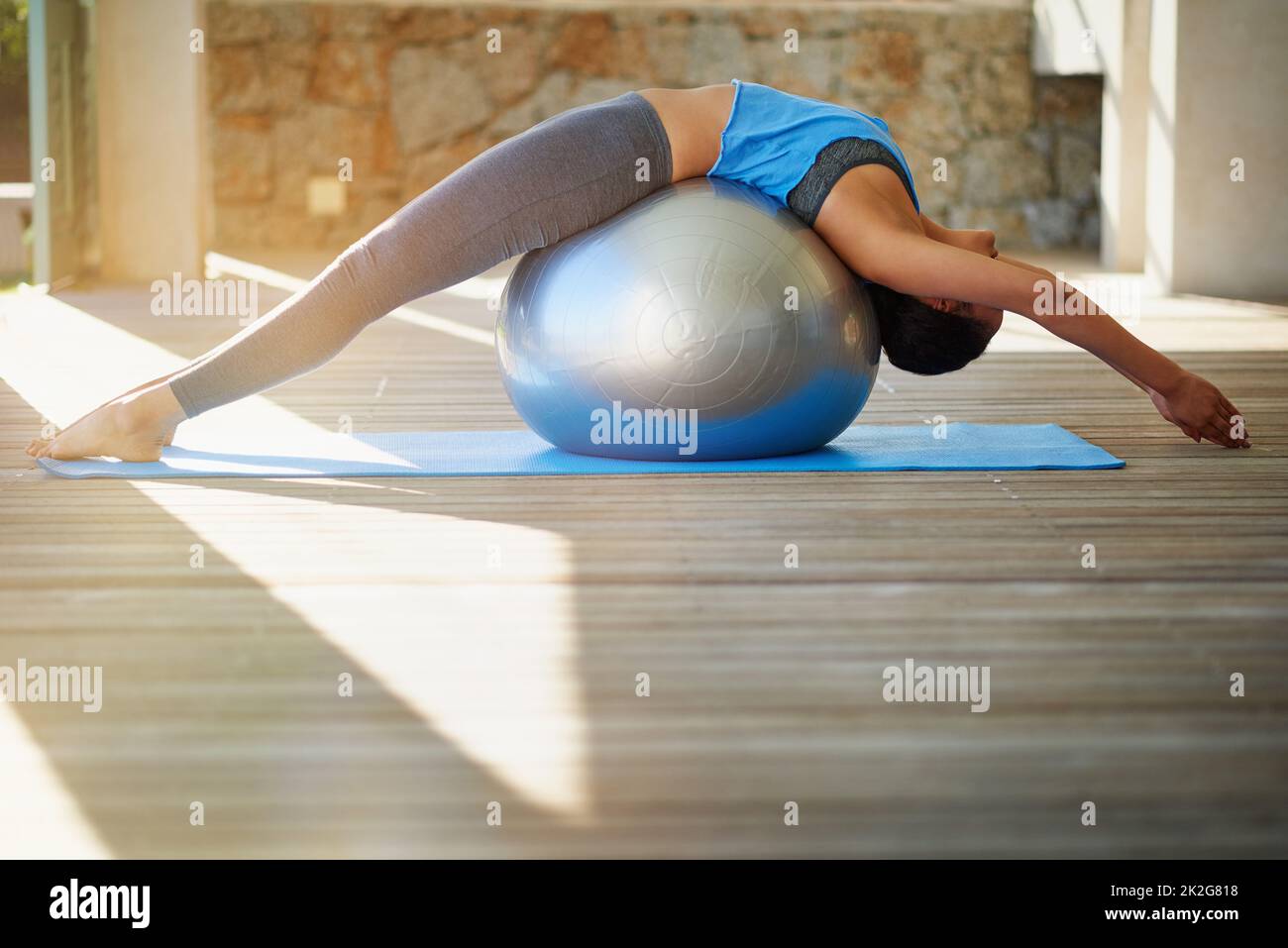 Tonificare tutto il corpo. Shot di una giovane donna che pratica lo yoga a casa. Foto Stock