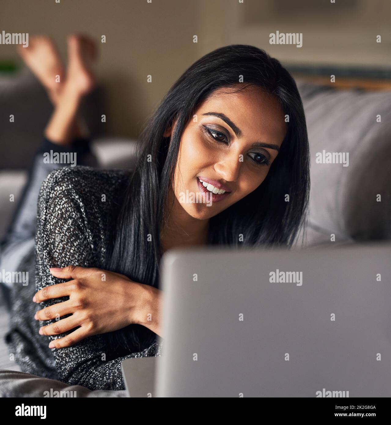 Blogging è un senso grande spendere il vostro tempo libero. Scatto di una giovane donna attraente che naviga in rete mentre si trova sul suo divano a casa. Foto Stock