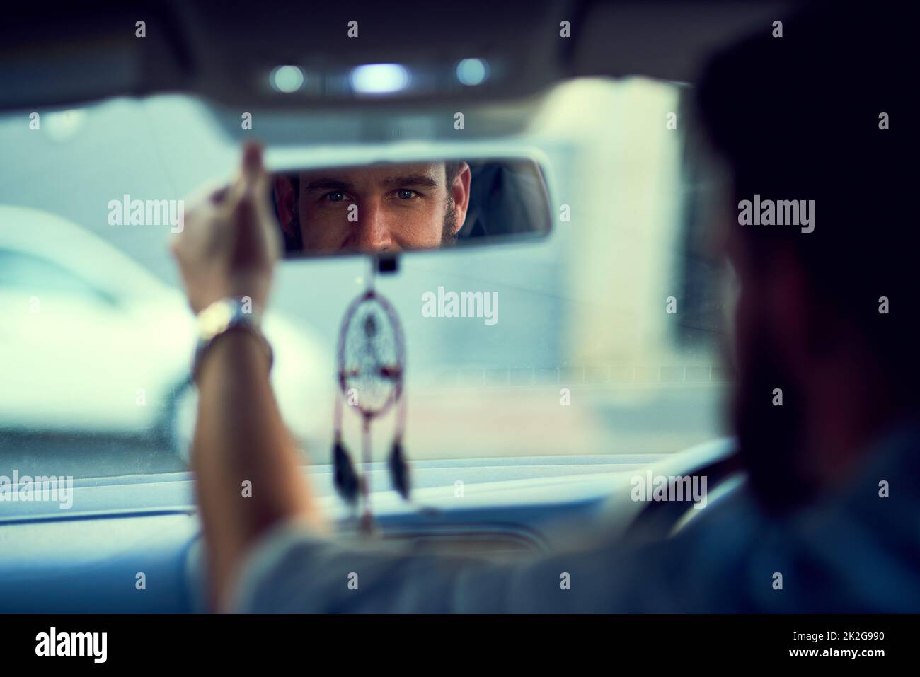 Sono pronto per la giornata. Scatto all'indietro di un uomo irriconoscibile che guida in auto guardando nello specchietto retrovisore. Foto Stock