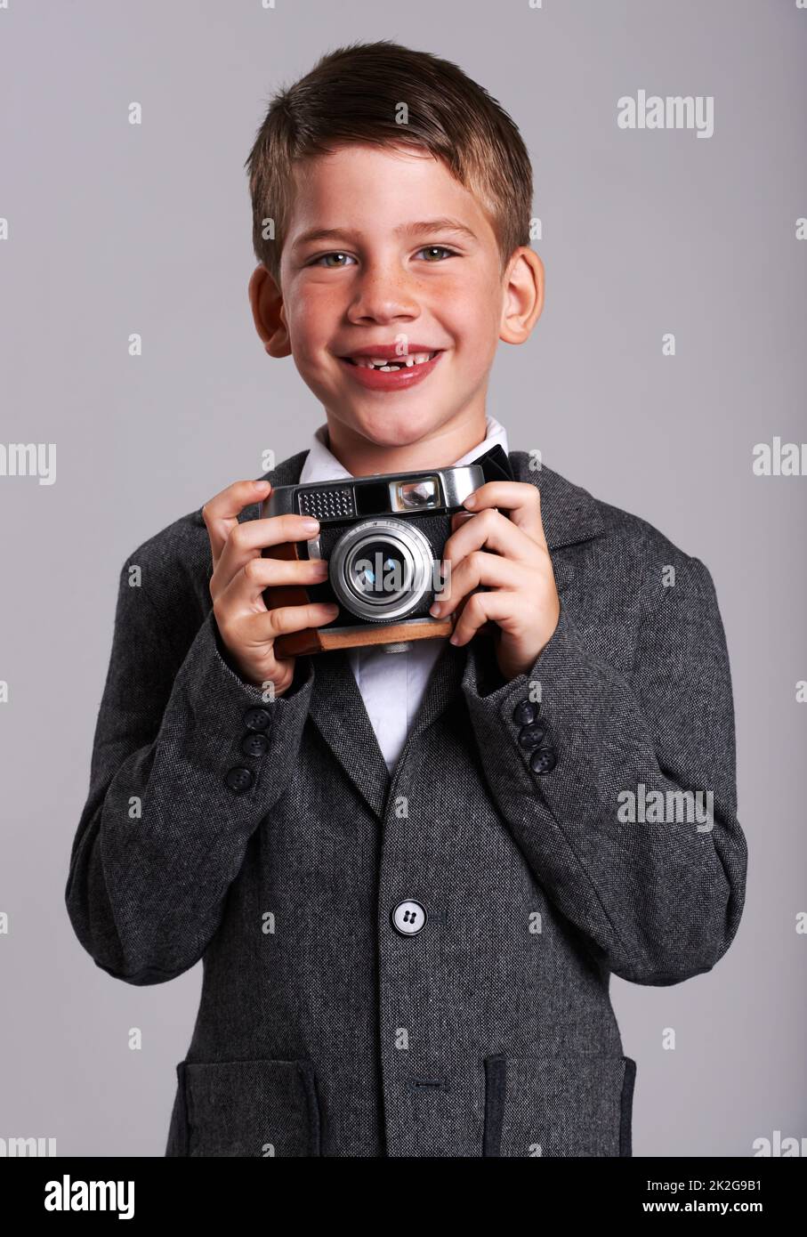 Giovane Weegee. Studio girato di un ragazzo in un vecchio vestito con una fotocamera vintage. Foto Stock