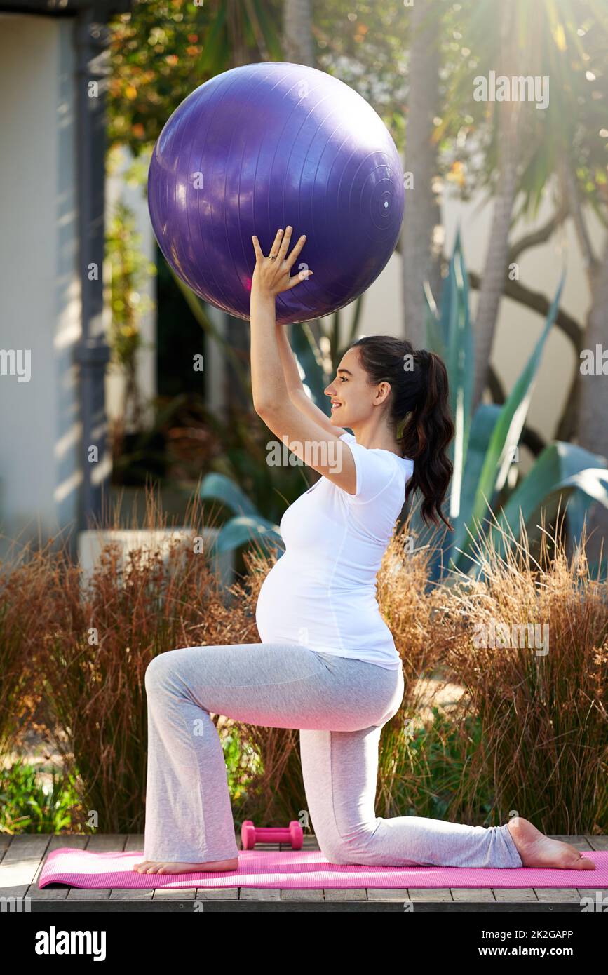 Stare in forma durante tutta la gravidanza. Shot di una giovane donna incinta che si esercita all'esterno. Foto Stock