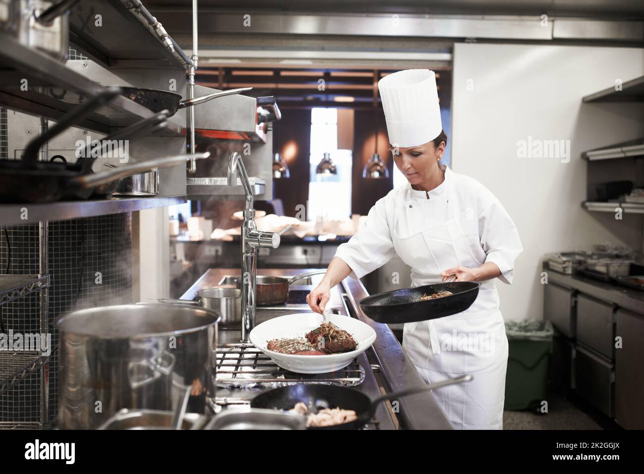 Mangiare è necessario, ma la cucina è un'arte. Colpo di chef preparare un servizio di pasto in una cucina professionale. Foto Stock