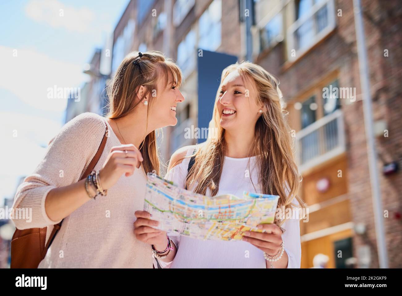 Meglio non perderci. Inquadratura a basso angolo di due giovani amiche che leggono una mappa mentre esplorano una città straniera. Foto Stock