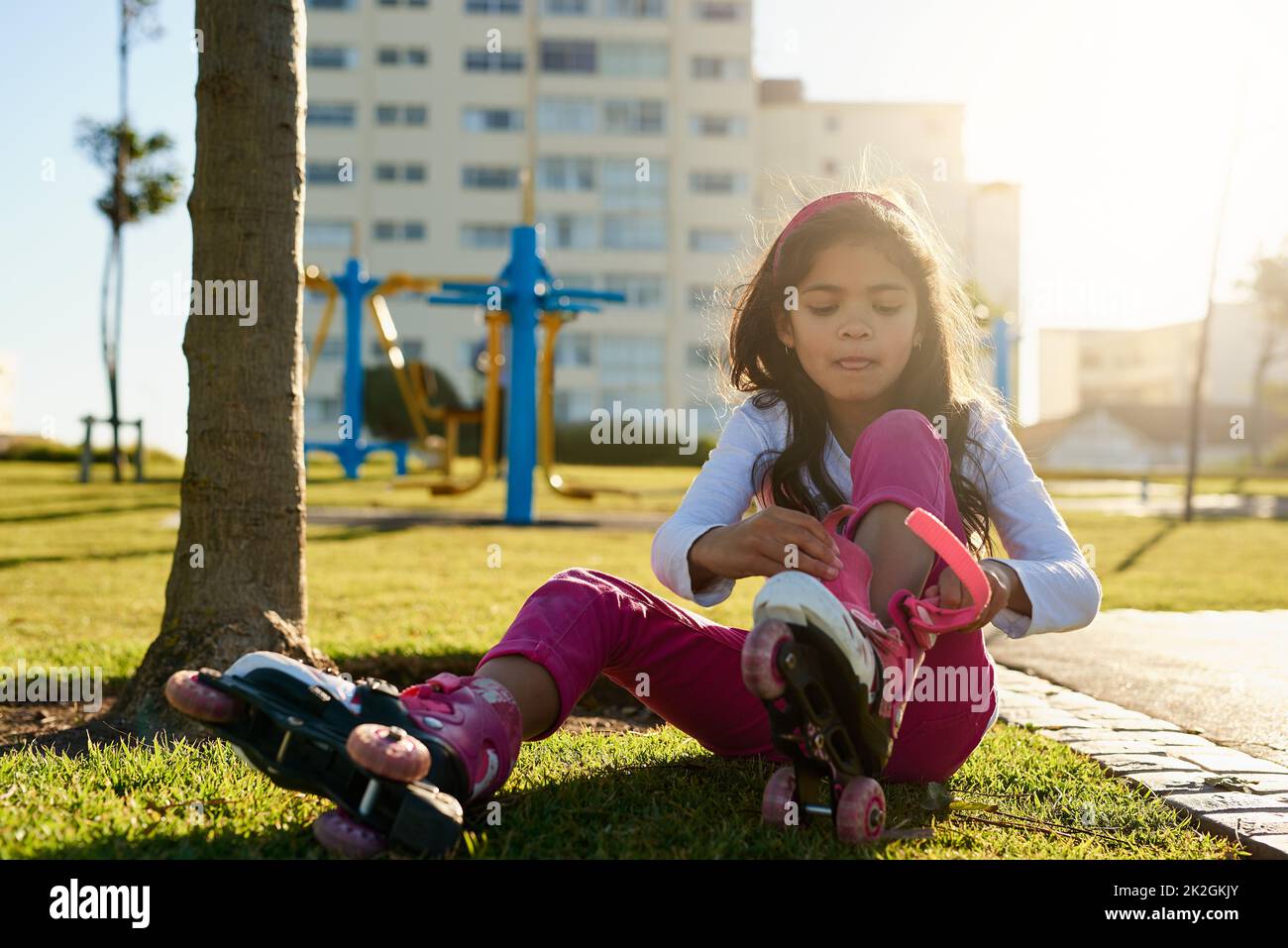 Pronto a far salire il suo skate. Scatto di una giovane ragazza che mette sui suoi pattini a rotelle al parco. Foto Stock