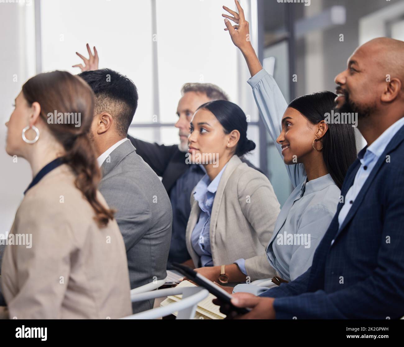 Mi piace sentire le tue domande. Shot di un gruppo di persone aziendali che pongono domande durante una conferenza. Foto Stock