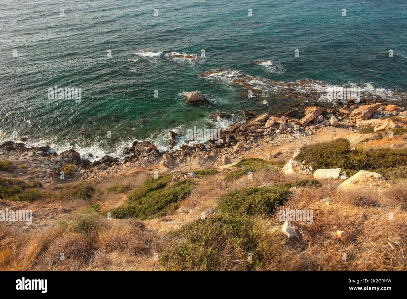 Vista dal mare ripida collina shore ricoperte di erba, rocce e mare blu profondo di acqua in background. Karpass, la parte settentrionale di Cipro Foto Stock