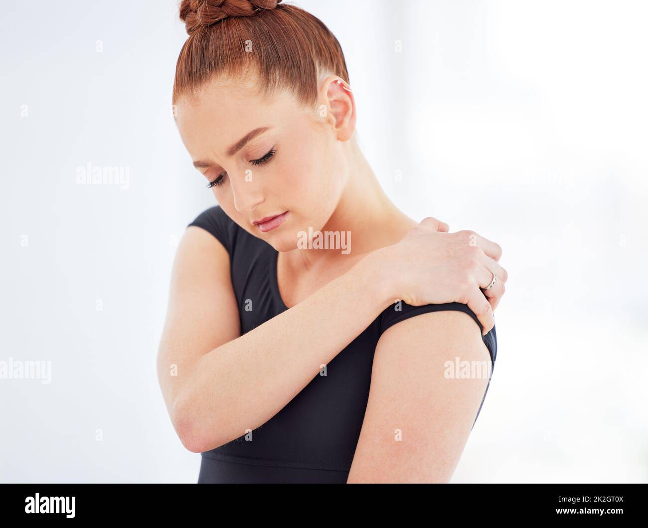 In qualsiasi sport possono verificarsi lesioni e il balletto non fa eccezione. Colpo di una giovane ballerina che soffre di dolore alla spalla. Foto Stock