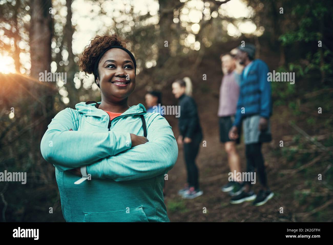 La foresta è un luogo ideale per allenarsi. Ripresa ritagliata di una giovane donna sportiva pronta ad allenarsi mentre aspetta i suoi amici sullo sfondo nella foresta. Foto Stock