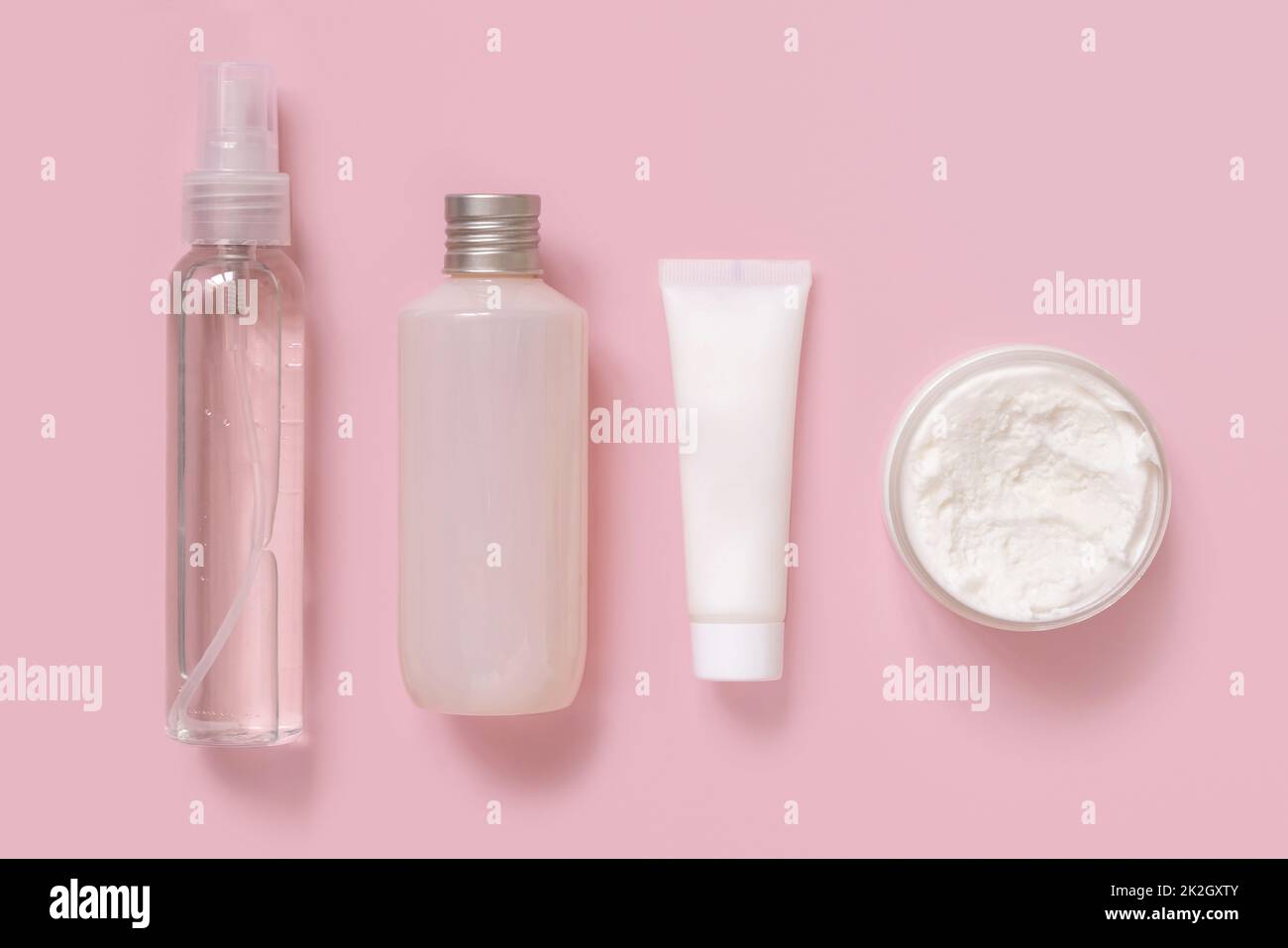 Cosmetici fatti in casa in tubi di plastica e bottiglie in vista rosa dall'alto. Modello di imballaggio del marchio. Foto Stock