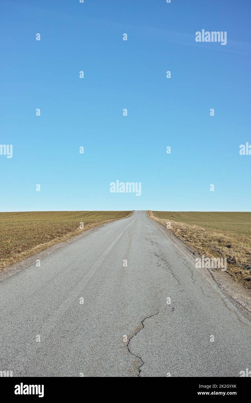 Bei viaggi, una strada vuota attraverso la campagna. Foto Stock