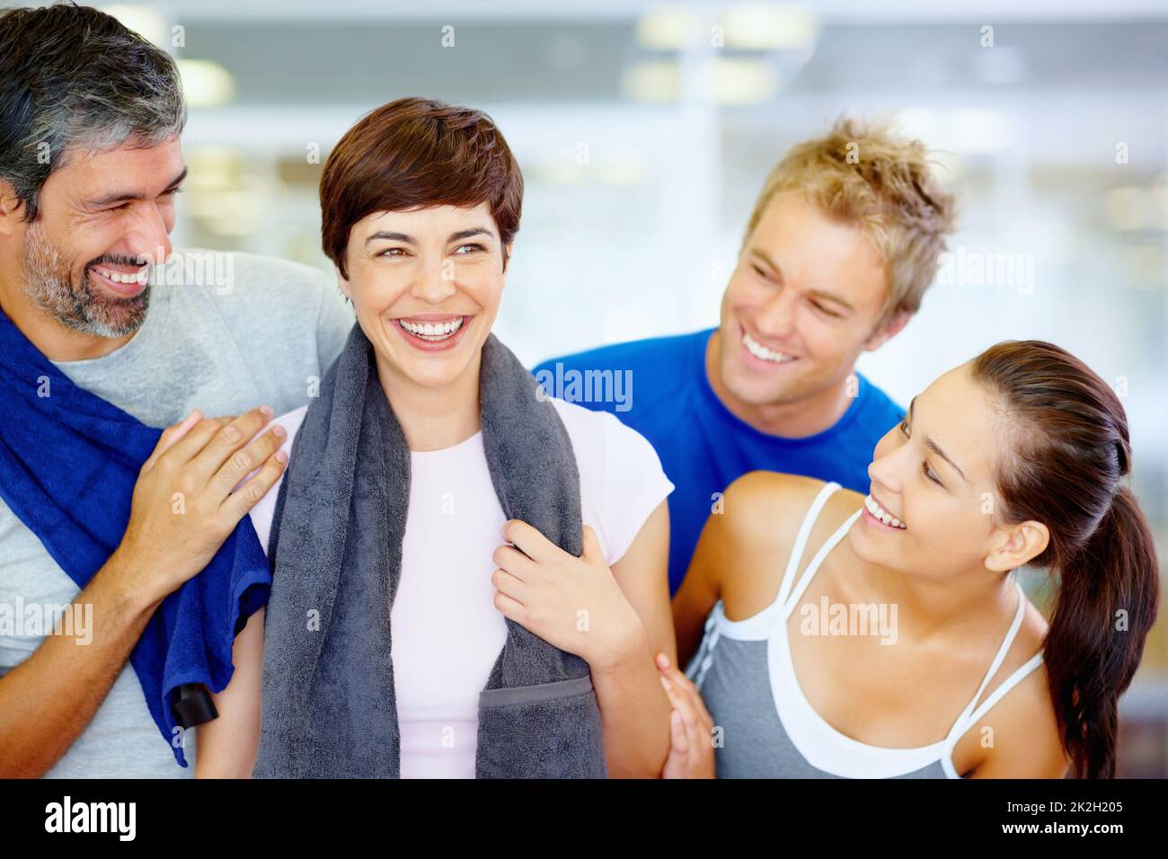 Amici allegri al centro fitness. Ritratto di bella donna che tiene un asciugamano con i suoi amici al centro fitness. Foto Stock