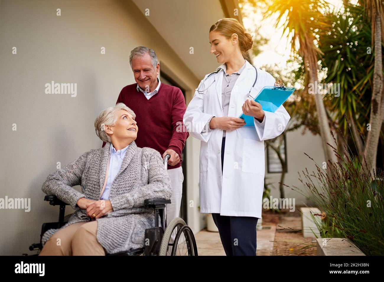 Niente la rende più felice della dimissione di un paziente sano. Shot di una coppia anziana e di un'infermiera fuori da una casa di cura. Foto Stock