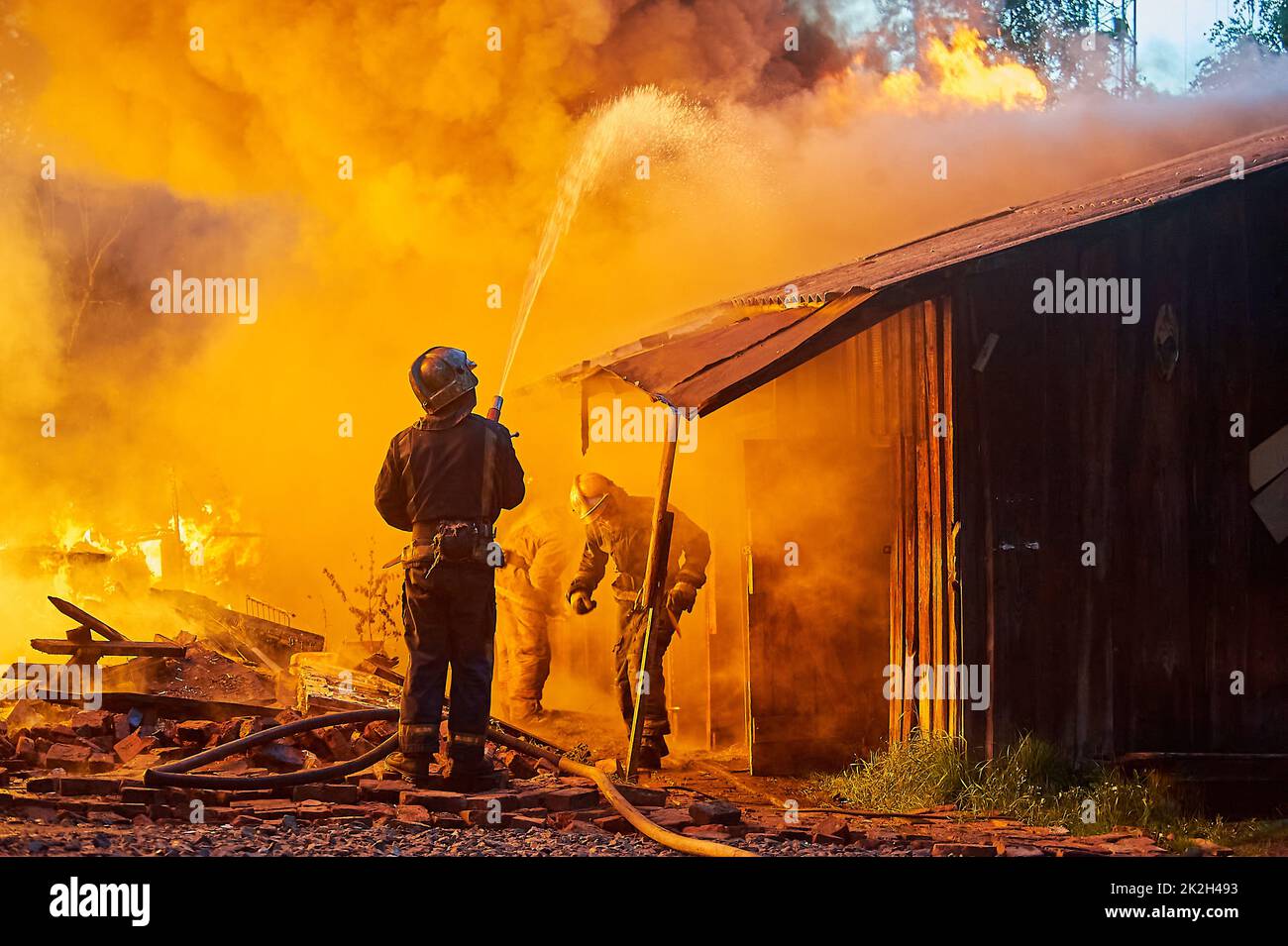 I vigili del fuoco spengono un incendio in un edificio di fattoria Foto Stock