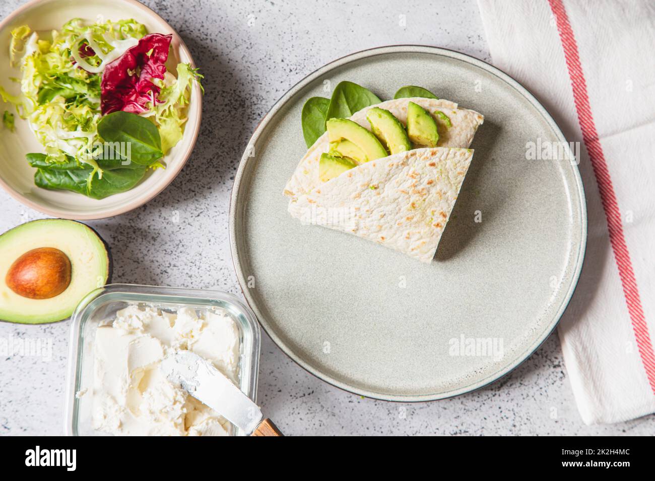 Processo di cottura per sandwich e ingredienti. Processo di preparazione del quesadilla con avocado, salmone, formaggio cagliato e spinaci. Un hack alla moda. Passo dopo passo. Passaggio 4 Foto Stock