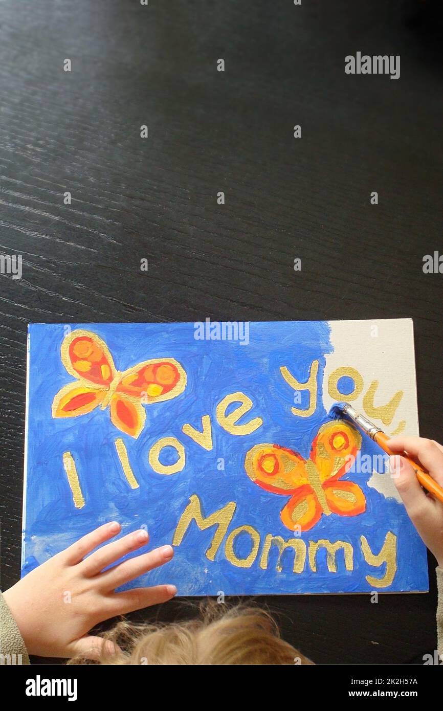 mano di un bambino che dipinge un'immagine per la mamma Foto Stock