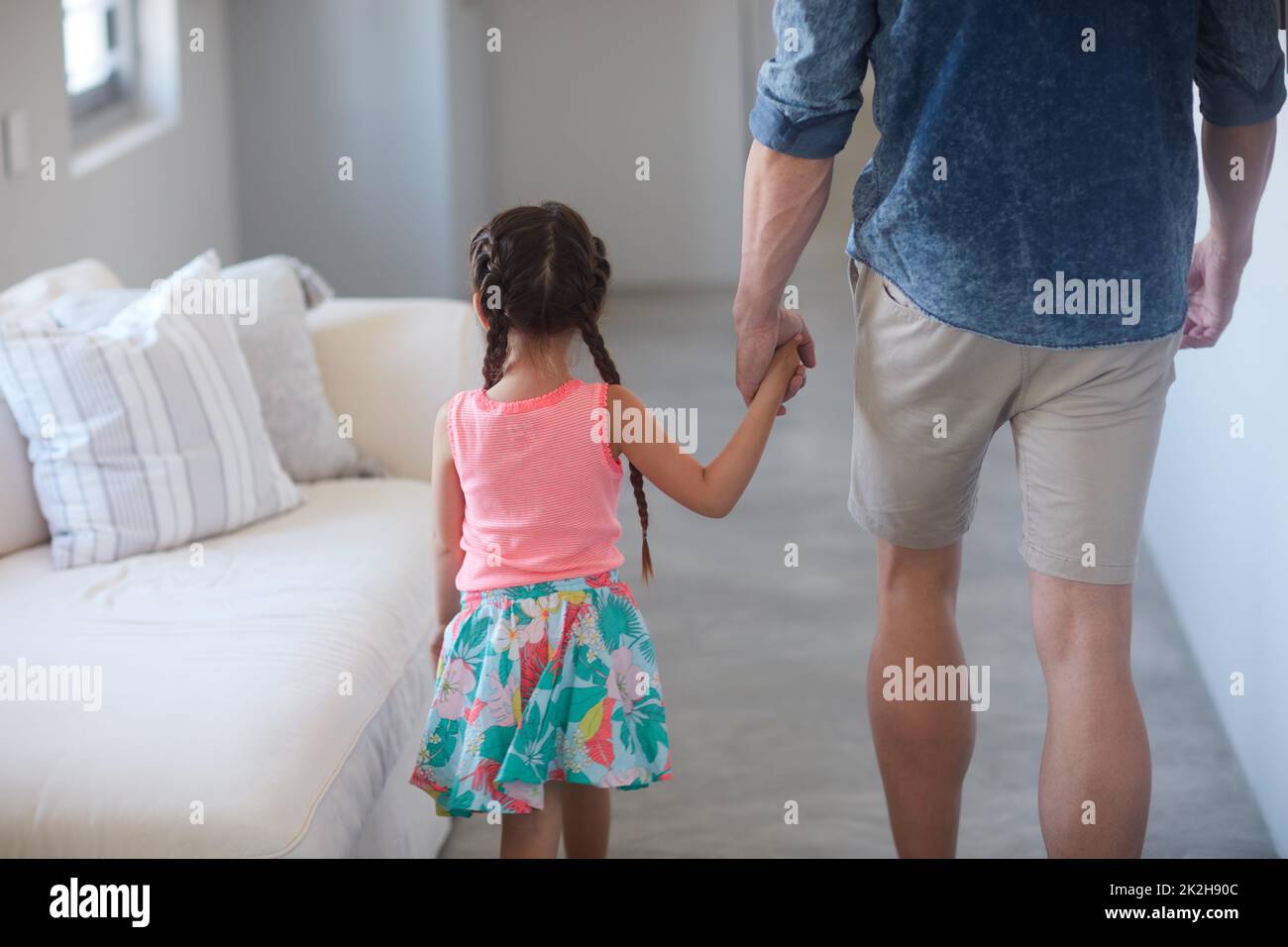 Vuole andare ovunque va papà. Fucilato di un padre e di una figlia che trascorrono del tempo insieme a casa. Foto Stock