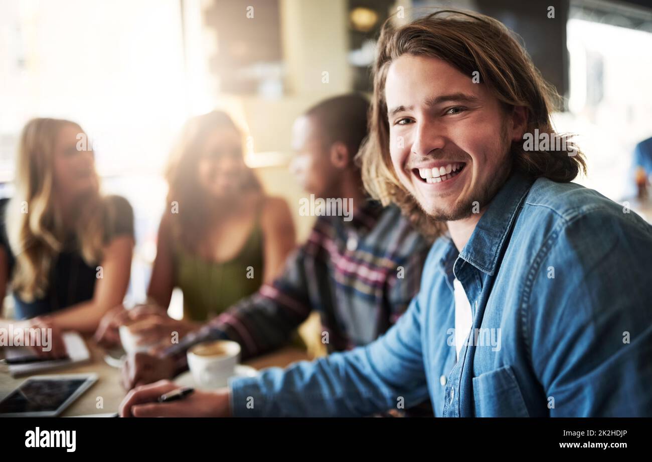 Parte della pista. Ritratto di un uomo che ha un caffè con gli amici in una caffetteria. Foto Stock