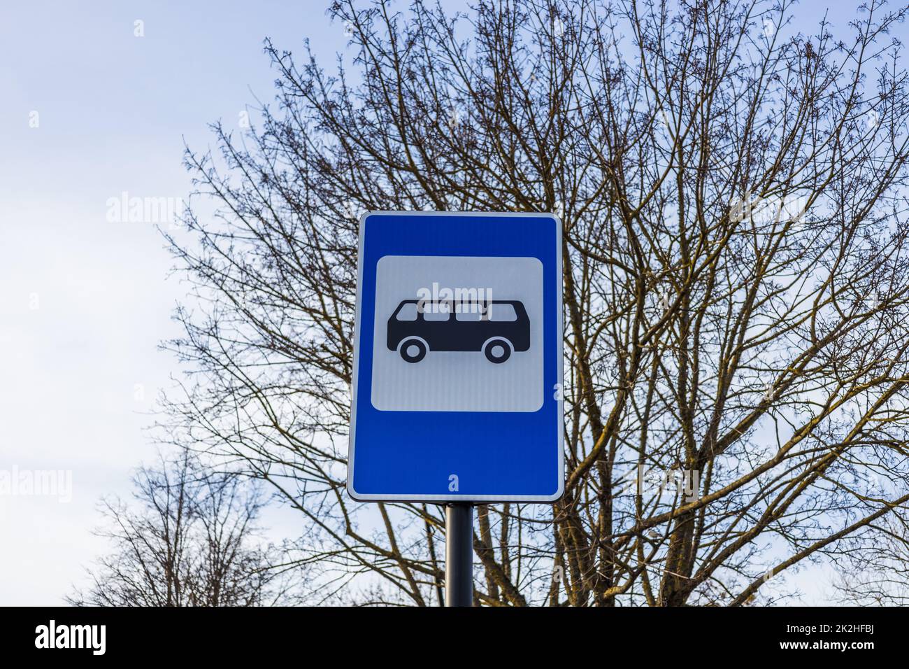 Segnale blu e bianco della fermata dell'autobus in Europa sullo sfondo del cielo Foto Stock