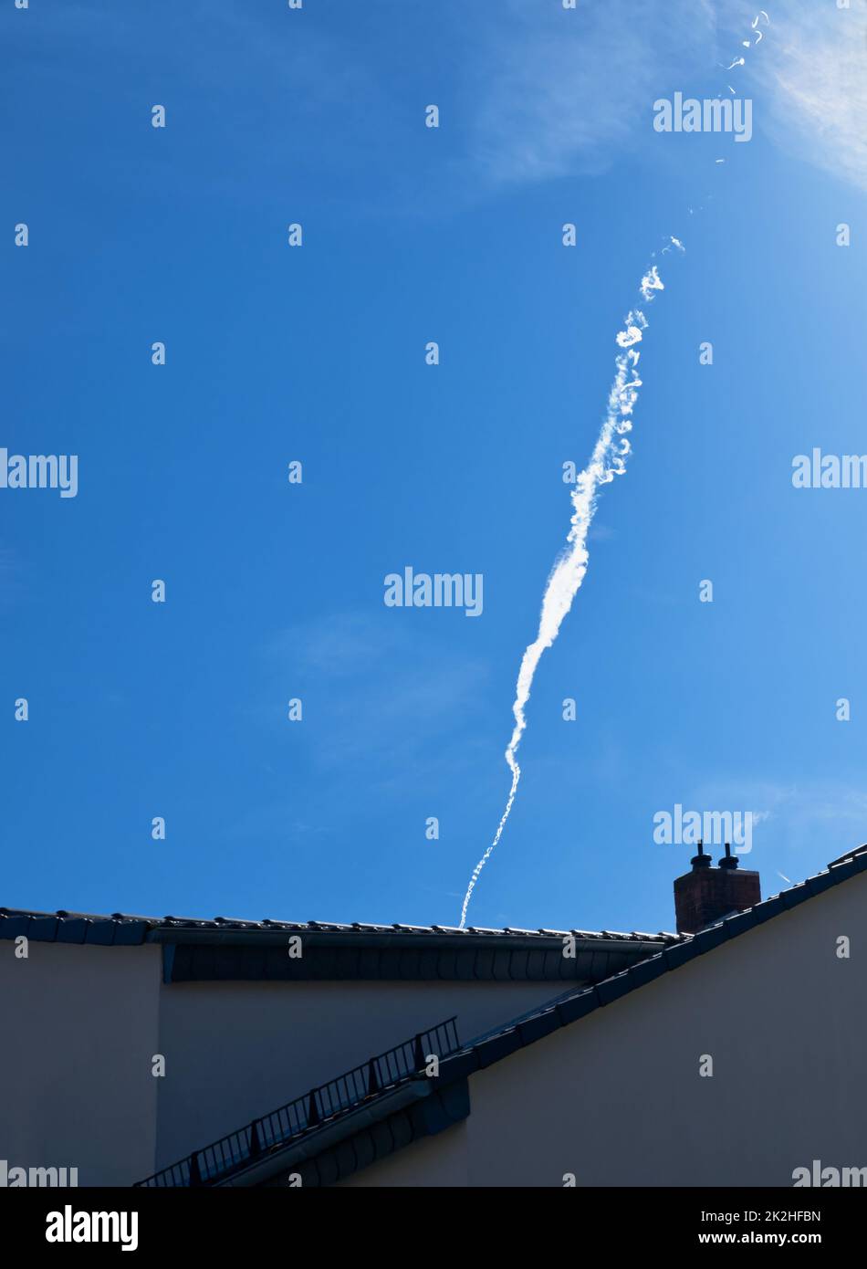 prove al vapore, insolitamente e interessanti, modellate, svanite, curling, ascendenti sopra le cime del tetto nel cielo, assomigliare a fumo di camino bianco, simbolico Foto Stock