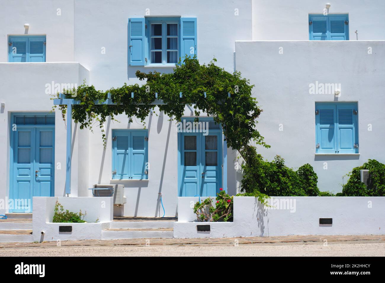 Case tradizionali di architettura greca dipinte di bianco con porte blu e persiane Foto Stock