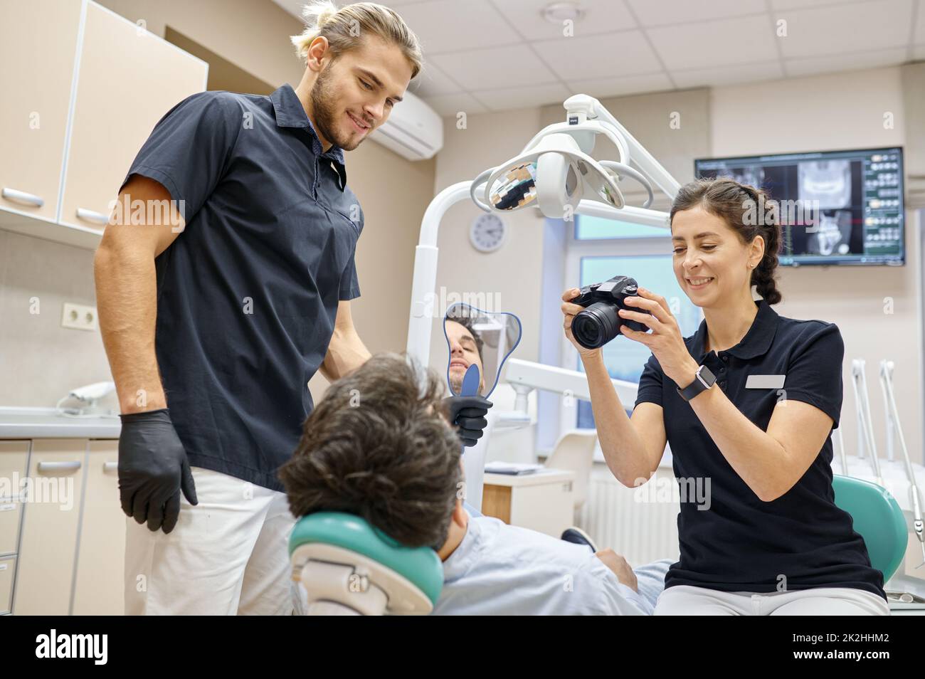 Dentista che fotografa i denti del paziente dopo il trattamento Foto Stock