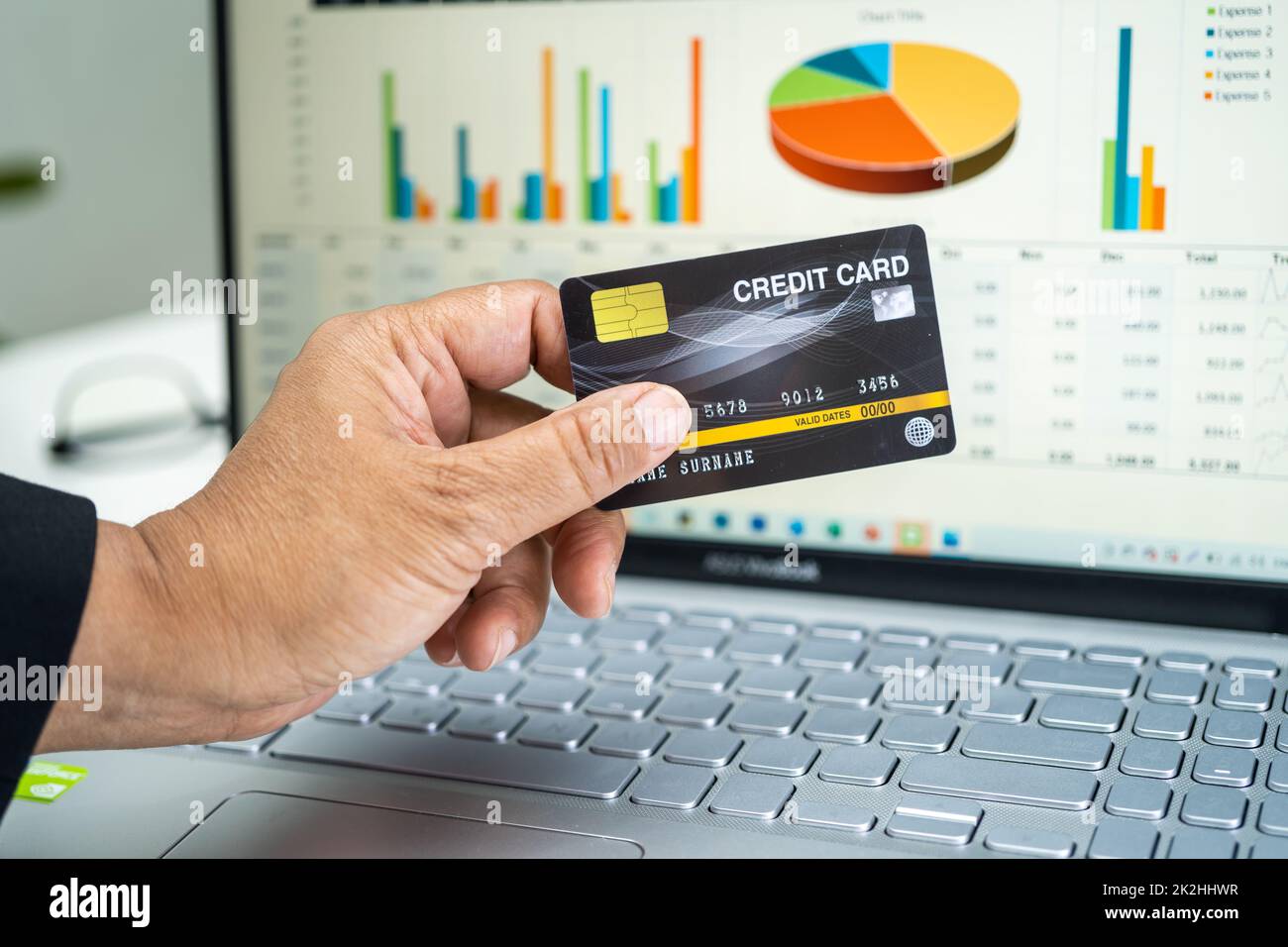 Ragioniere asiatico lavorare, calcolare e analizzare report di contabilità progetto con notebook e carta di credito in moderno ufficio, finanza e business concept. Foto Stock