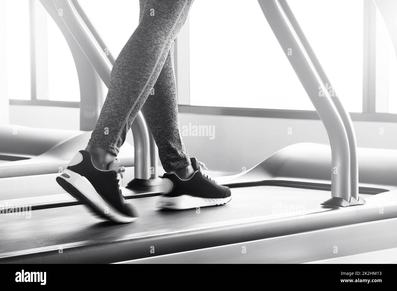 Gambe femminili su un tapis roulant con effetto sfocatura del movimento Foto Stock