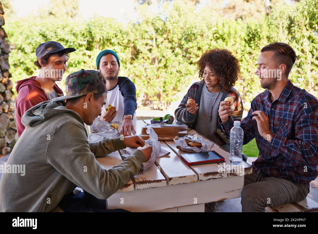 Ritrovo con gli amici. Un gruppo di amici intorno ad un tavolo all'aperto. Foto Stock