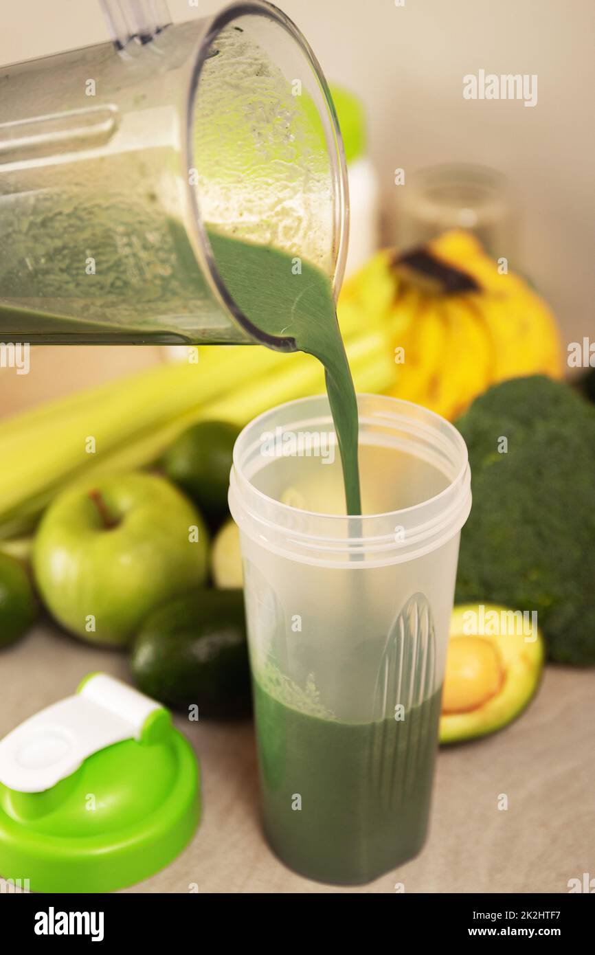 Versare un cocktail vegetariano verde nello shaker Foto Stock