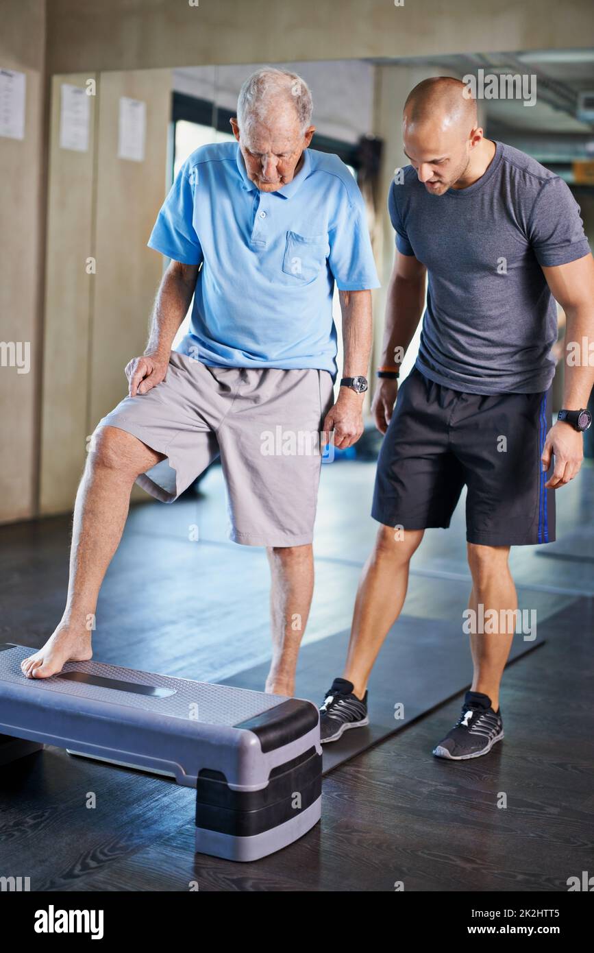 Youre fare un certo progresso grande. Un allenatore che aiuta un uomo anziano con il fitness. Foto Stock