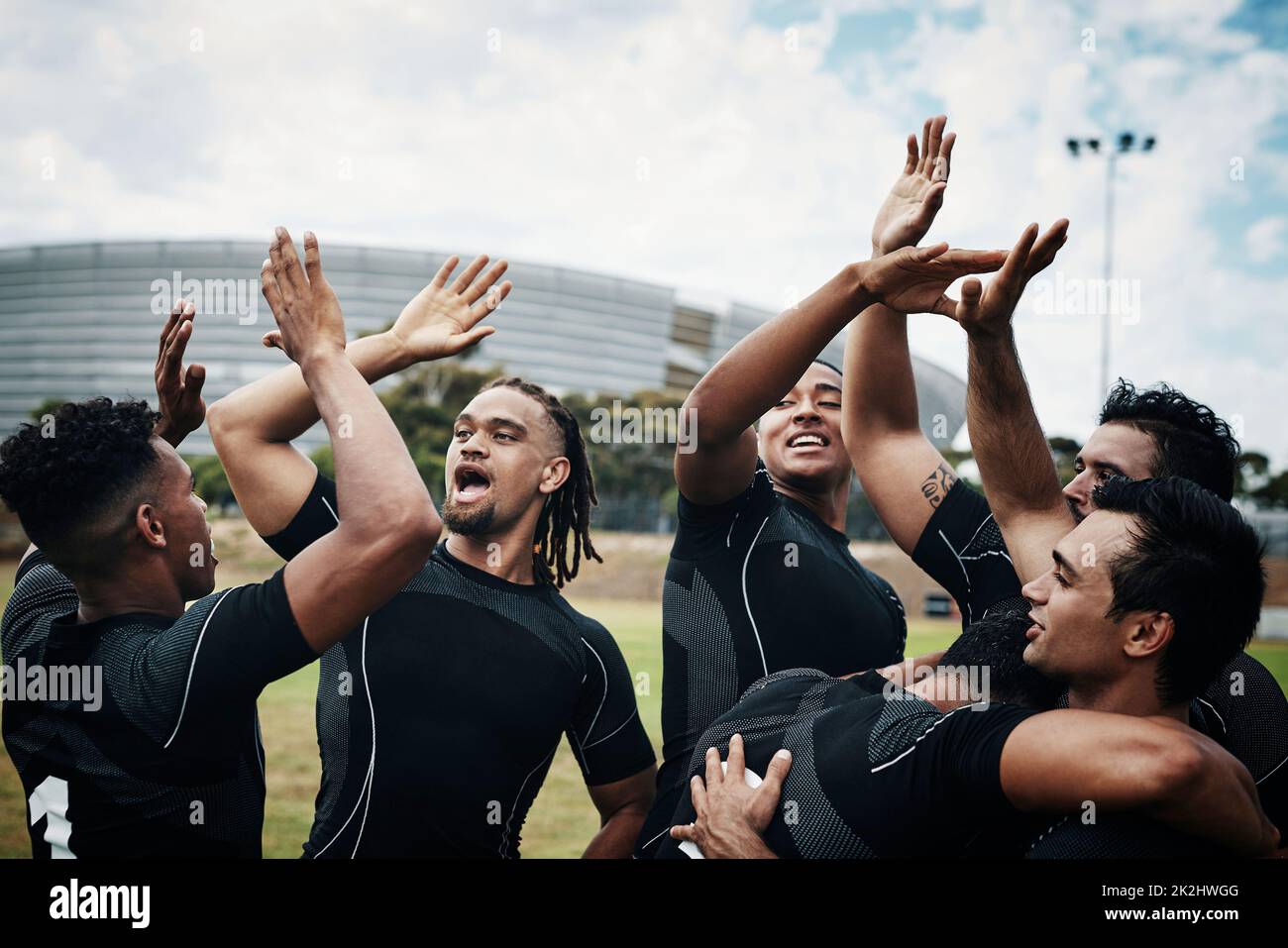 Sono così grandi a vincere. Scatto corto di una squadra di giocatori di rugby che festeggia mentre si è in piedi sul campo durante il giorno. Foto Stock