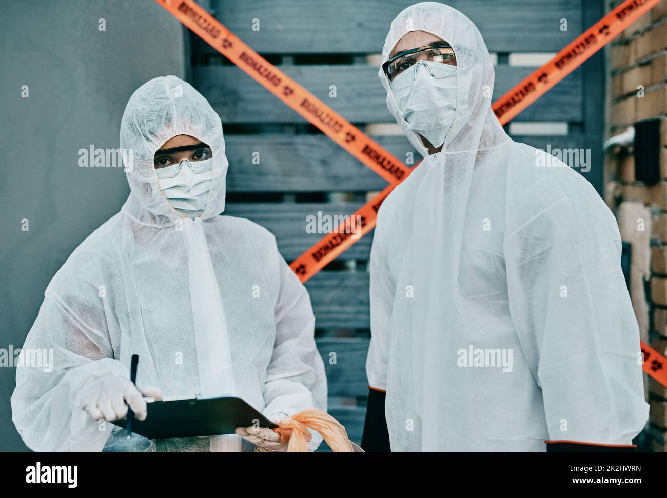 Lavorare insieme per salvare il mondo. Shot di due operatori sanitari che indossano tute di nocciolo che lavorano insieme per controllare un focolaio. Foto Stock