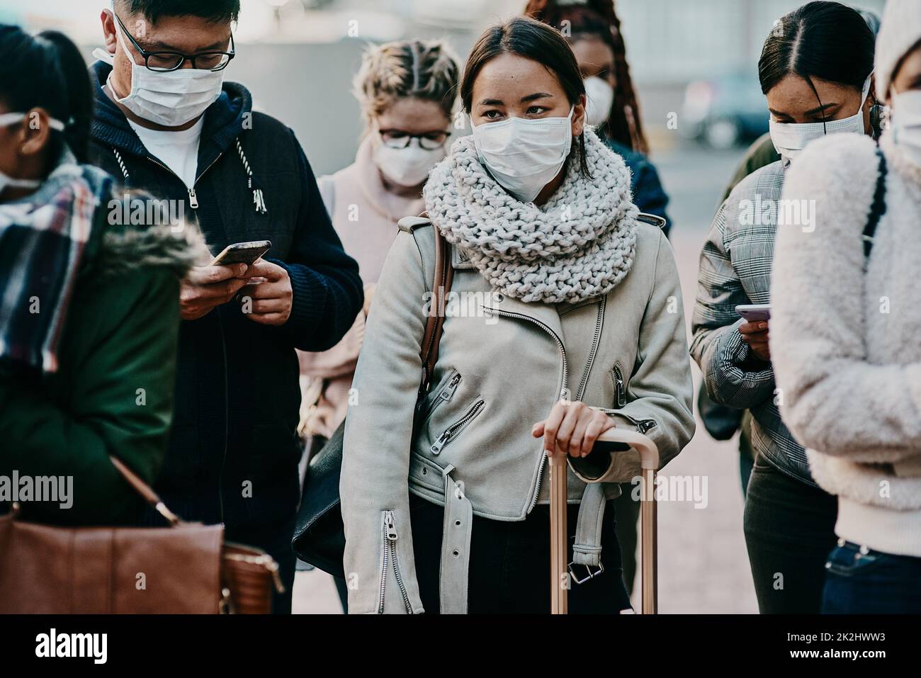 Navigazione in un nuovo stile di vita. Girato di un gruppo di giovani che indossano le maschere durante il viaggio in una città straniera. Foto Stock