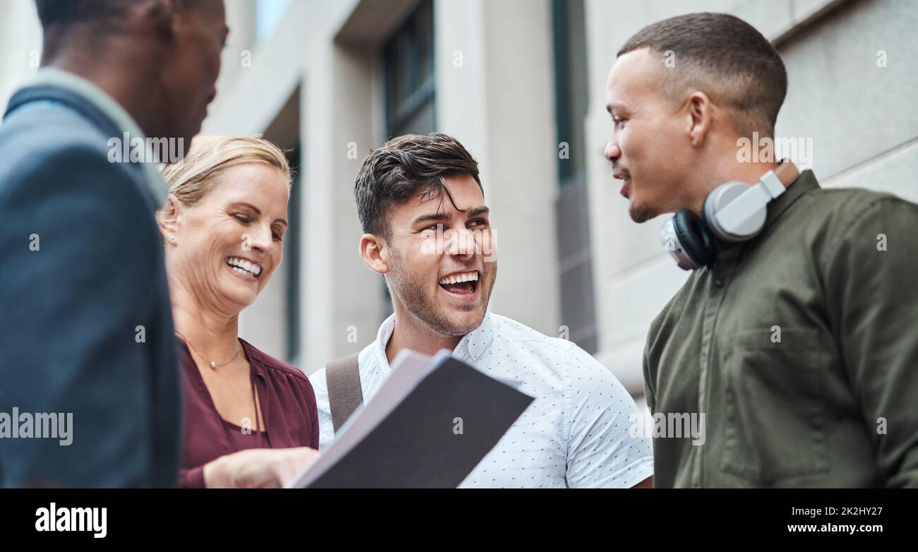 Il team di lavoro più duro della città. Colpo di un gruppo di uomini d'affari che hanno un incontro informale su un background urbano. Foto Stock