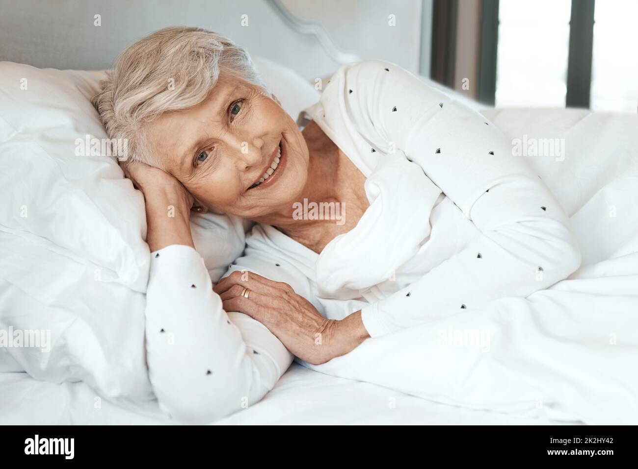 Il resto fa il mondo del bene. Shot di una donna anziana che si rilassa a letto in una casa di cura. Foto Stock