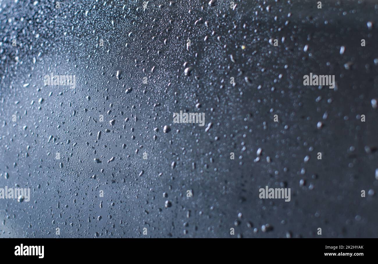 La parte posteriore della vettura bagnato dopo essere stato lavato in autolavaggi. Abstract 'drops di acqua sul vetro' dello sfondo. Foto Stock
