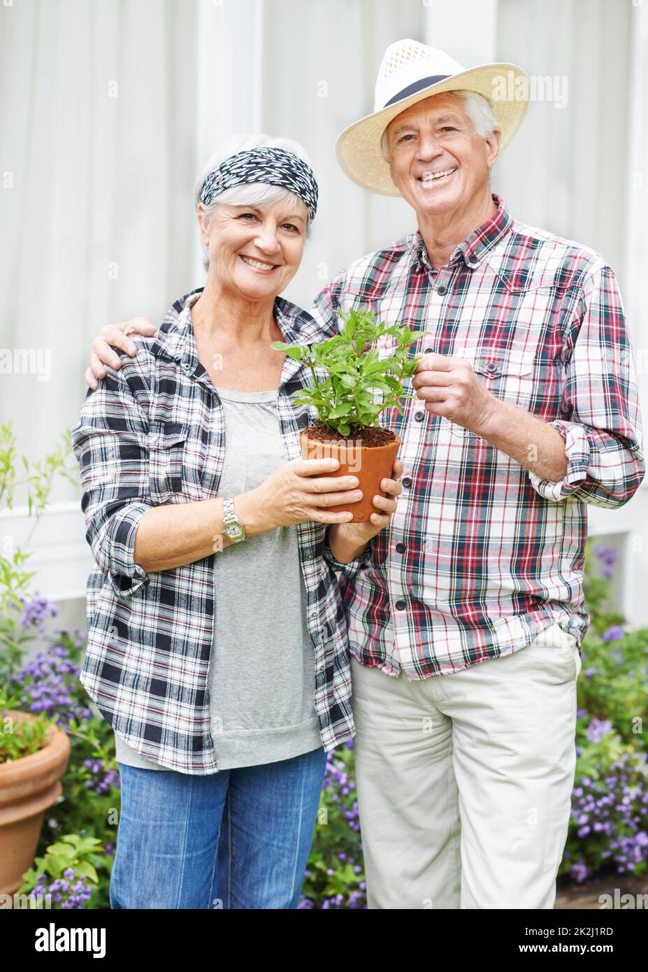 Weve non aveva mai avuto il tempo di giardinaggio prima. Una coppia anziana felice di giardinaggio occupato nel loro cortile posteriore. Foto Stock