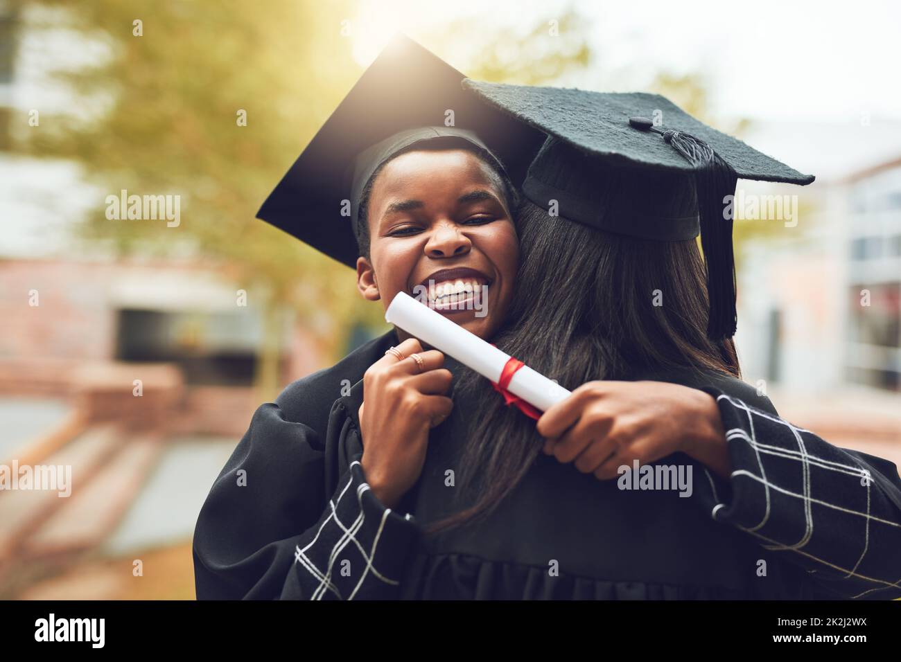 La nostra amicizia ci ha fatto passare molte notti lunghe. Shot di due laureati che si abbracciano il giorno della laurea. Foto Stock