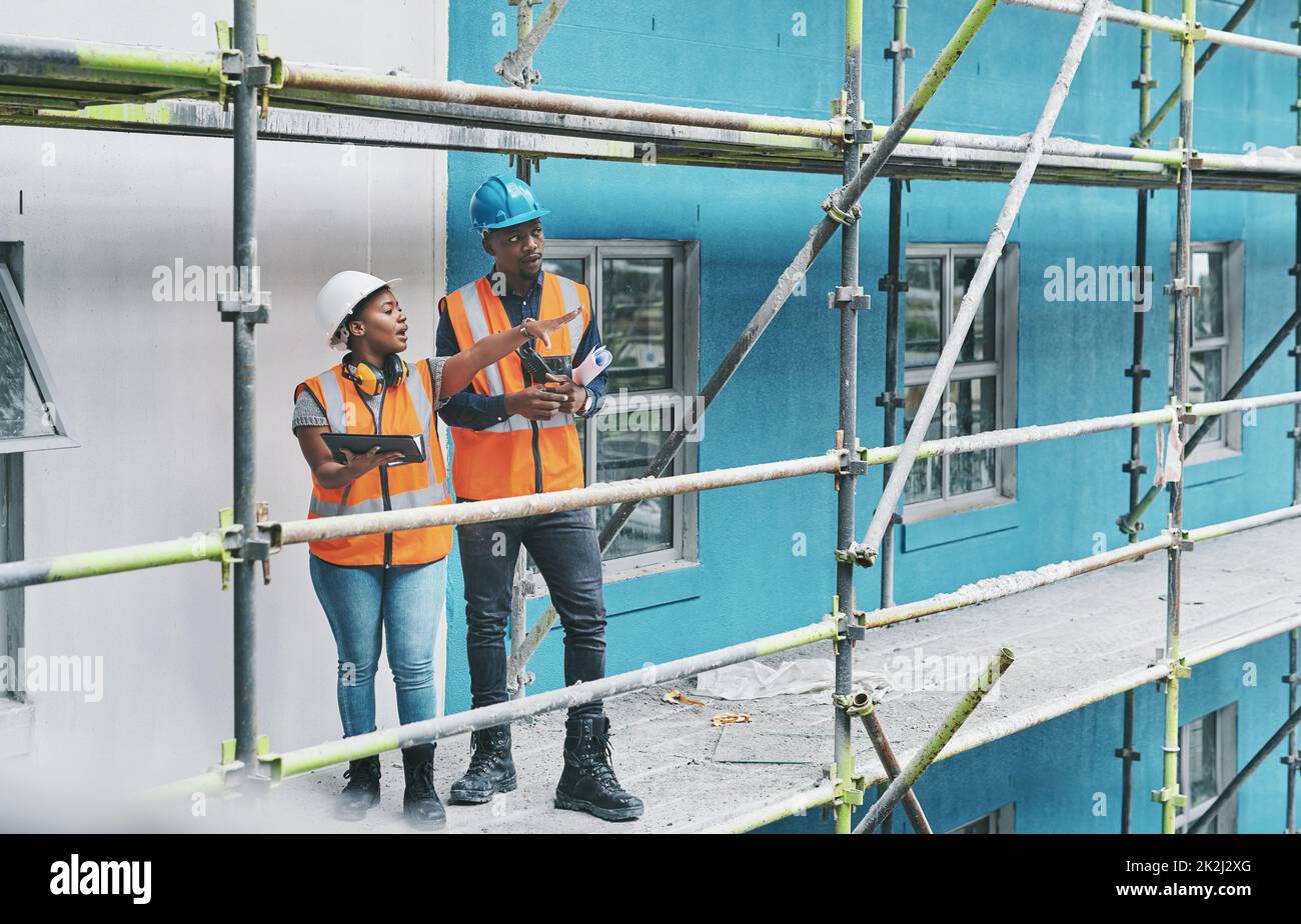 Plasmare il futuro della costruzione con l'aiuto di app intelligenti. Immagine di un giovane uomo e di una donna che utilizzano un tablet digitale mentre lavorano in cantiere. Foto Stock