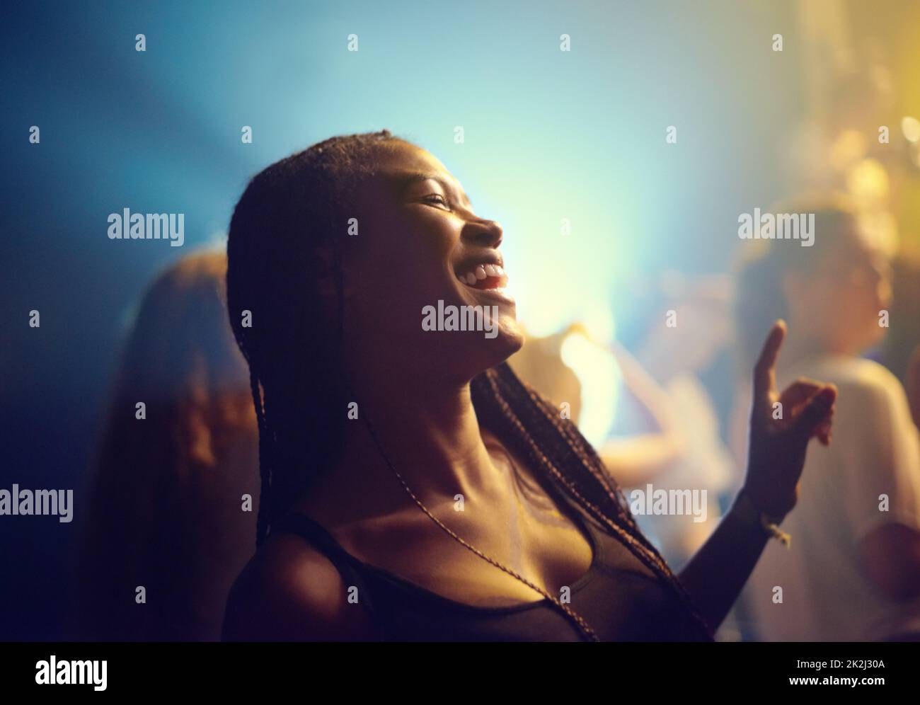 Una giovane ragazza che festeggiava in un club e si trasferiva alla musica. Questo concerto è stato creato per l'unico scopo di questo servizio fotografico, con 300 modelli e 3 band dal vivo. Tutte le persone in questo sparo sono modello rilasciato. Foto Stock