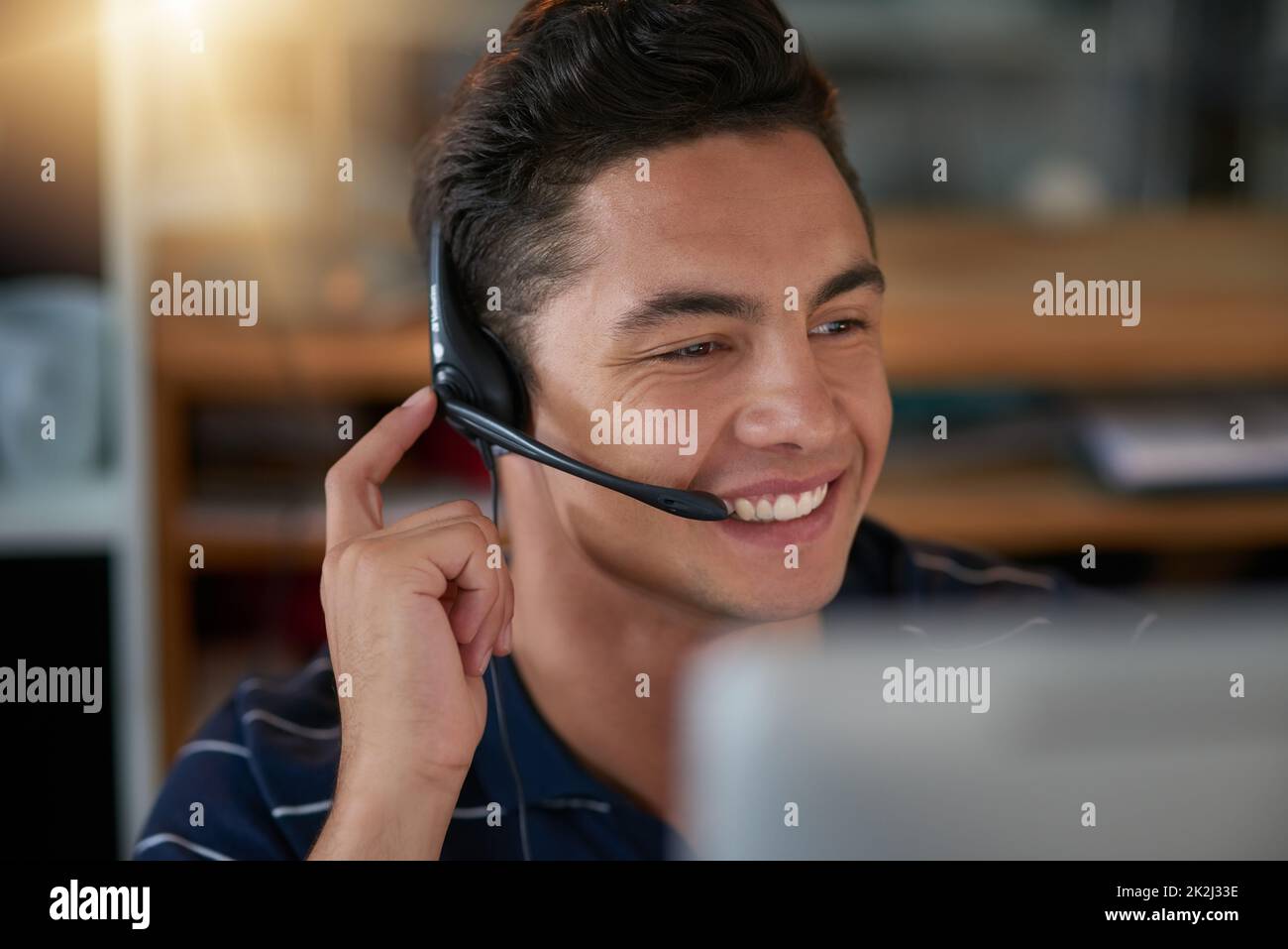 Immagine di un giovane agente maschile che lavora in un call center. Foto Stock