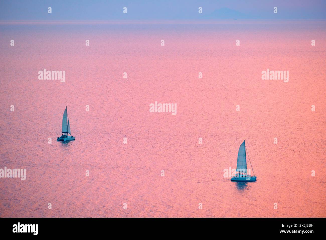 Yacht turistici in barca nel Mar Egeo vicino all'isola di Santorini con i turisti che guardano il punto panoramico del tramonto. Santorini, Grecia Foto Stock