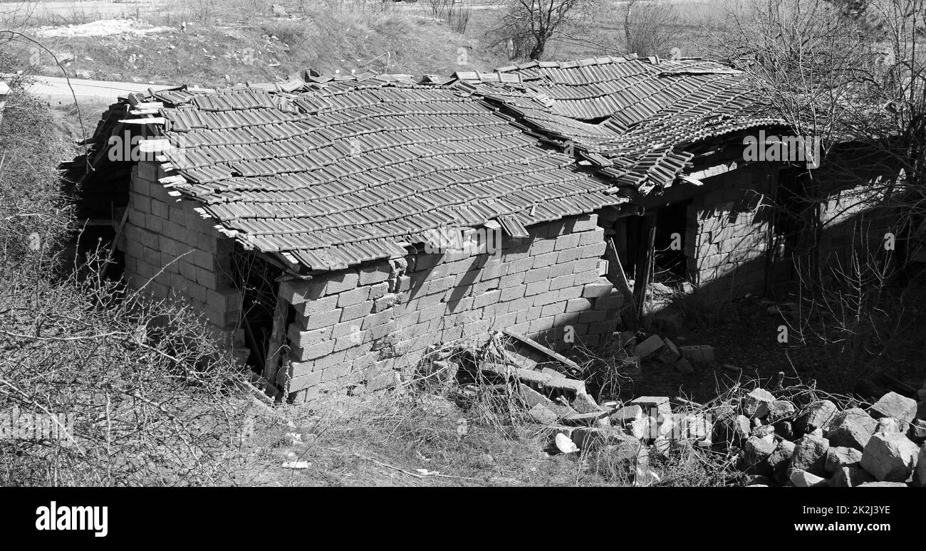 una vecchia casa con un tetto in caduta - una vecchia casa sull'orlo del collasso Foto Stock