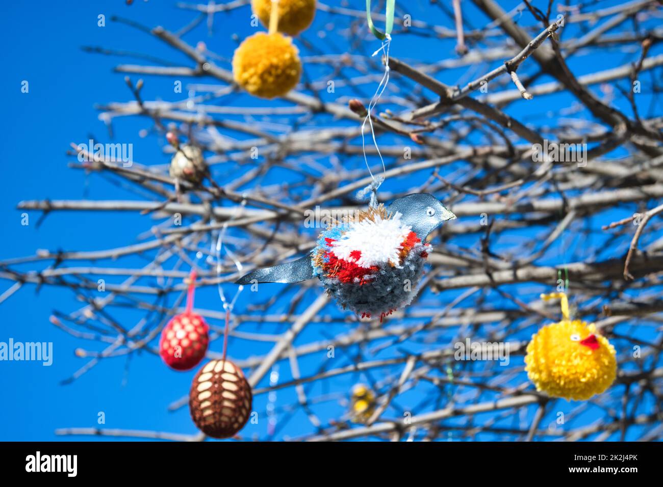 Colorate decorazioni pasquali appese su rami di albero Foto Stock