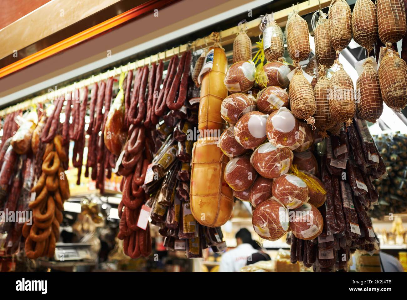 Mercato degli amanti della carne. Salsicce secche e salumi appesi agli uncini in una bancarella del mercato. Foto Stock