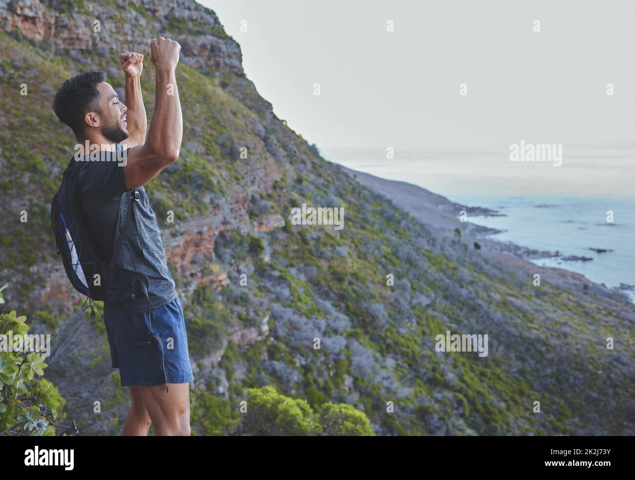 Mi sfida sempre a fare meglio. Scatto di un giovane che celebra il completamento della sua escursione in cima alla montagna. Foto Stock