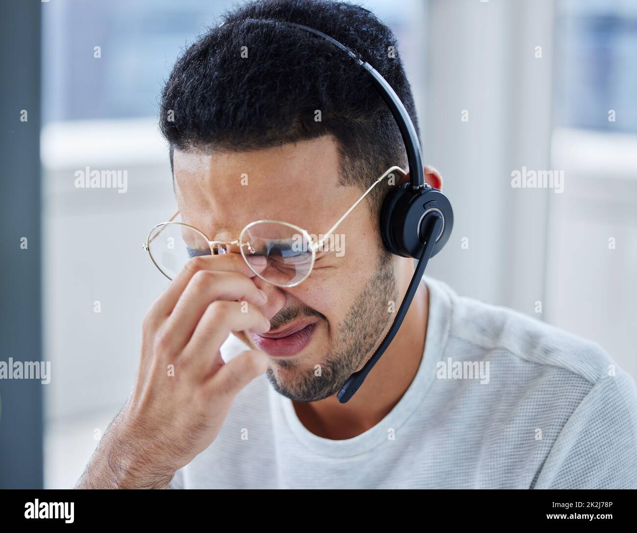 Questo cliente mi ha sottolineato. Shot di un giovane uomo d'affari che soffre di mal di testa alla sua scrivania nel suo ufficio. Foto Stock